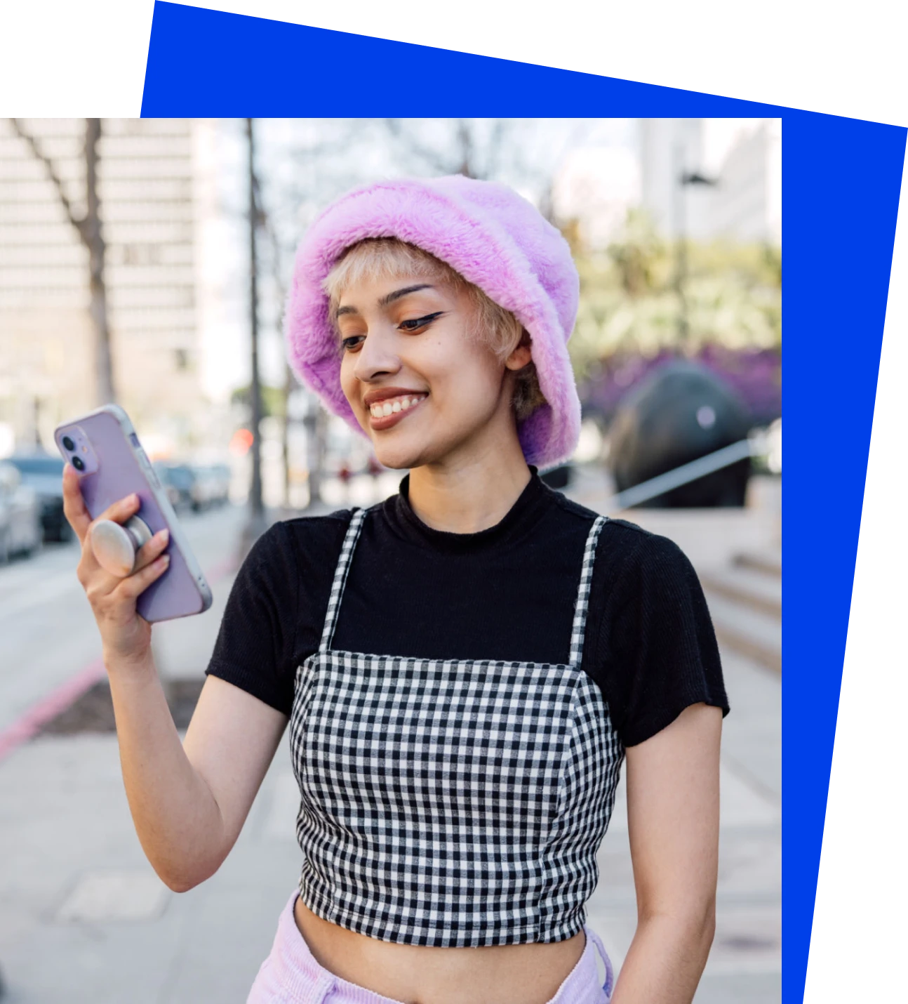 Person smiling at phone outdoors