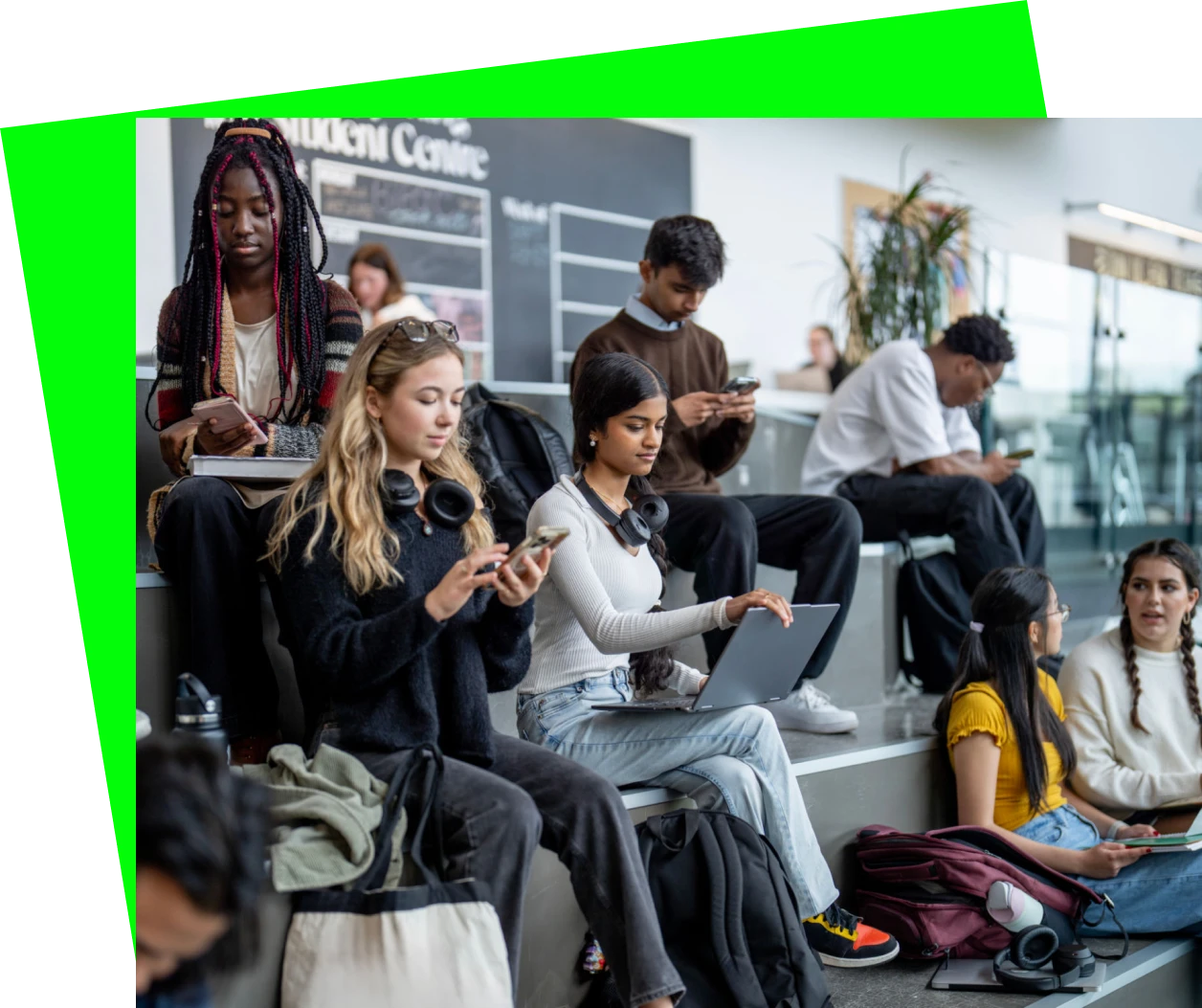 Young people focused on their phones and laptops